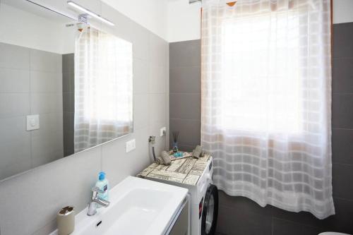 a bathroom with a sink and a mirror at Lux Apartment Aviano Centro AC Parking in Aviano