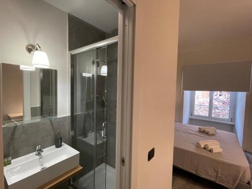 a bathroom with a sink and a shower and a bed at This must be the place Rome Guesthouse in Rome