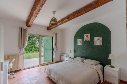 une chambre avec un grand lit et un mur végétal dans l'établissement La Provence : Piscine, Tennis, Cinéma & Plus, à Roquefort-les-Pins