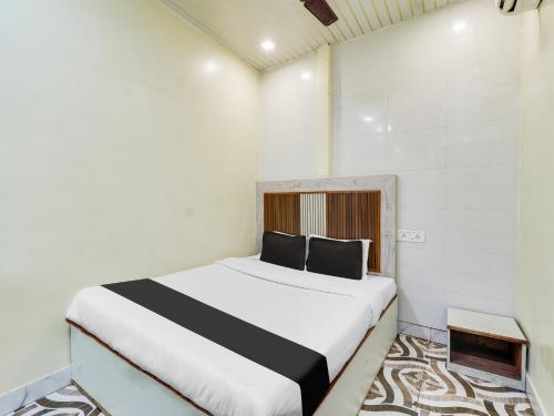 - une chambre avec un lit blanc et noir dans l'établissement OYO Hotel Metro View, à Mumbai