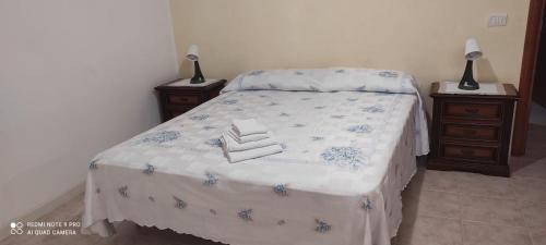 um quarto com uma cama com duas mesas de cabeceira e dois candeeiros em Il nido di Sofia em Policoro