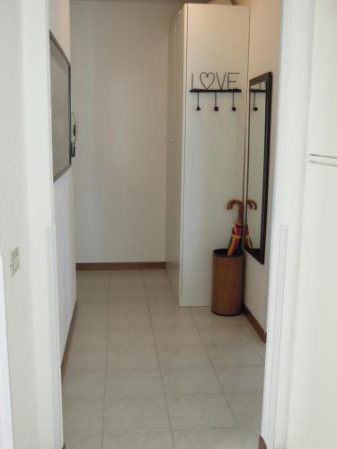 a hallway with white walls and a tile floor at A DREAM ON THE LAKE Via Roma in Lierna