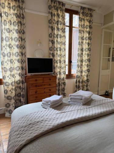 - une chambre avec un lit, une télévision et des rideaux dans l'établissement la campagne en ville, à Dieppe