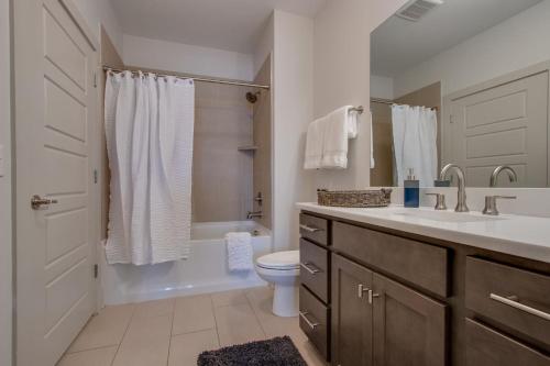 ein Badezimmer mit einem Waschbecken, einem WC und einer Badewanne in der Unterkunft New East Nash - King Bed Short Drive to Dwntwn in Nashville