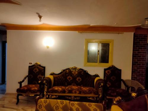 un soggiorno con 2 sedie e un divano di See view Alexandria شقة فندقية zahraa elagami ad Alessandria d'Egitto