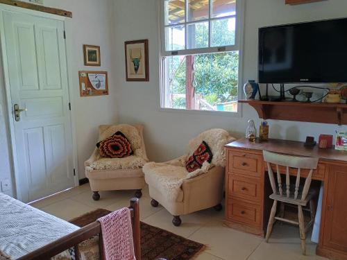 salon z 2 krzesłami i telewizorem w obiekcie Casa Verde w mieście Areal