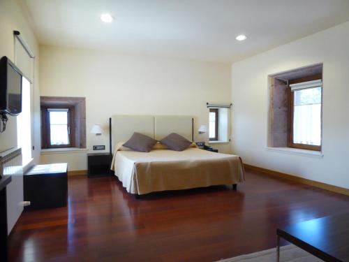 Hotel Jauregi Borda في Maya del Baztán: غرفة نوم بسرير في غرفة ذات أرضيات خشبية