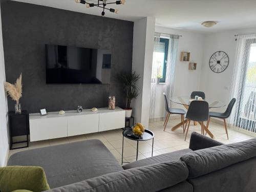 uma sala de estar com um sofá e uma mesa em Apartment Mare em Čunski