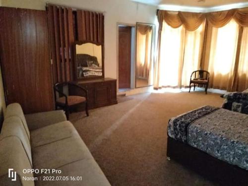 ナランにあるRoyal Saeed Hotelのソファとベッドのあるホテルの部屋