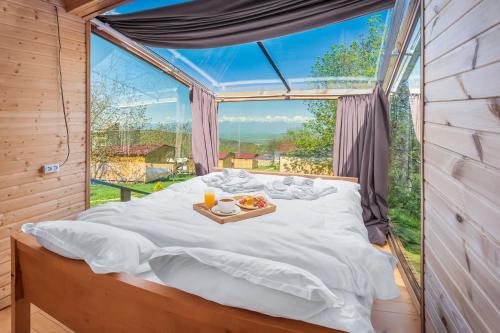 a bed in a room with a large window at Villaggio Mirzaani Resort in Sighnaghi