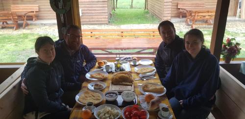 um grupo de pessoas sentadas à mesa com comida em PROKLETIJE eko katun Vusanje em Gusinje