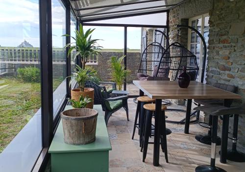 um pátio com uma mesa e cadeiras numa varanda em Vue unique sur le Mont St Michel em Huisnes-sur-Mer