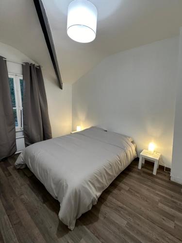 a bedroom with a large white bed and a table at Charmant 3 pièces boulevard de chanzy in Montreuil