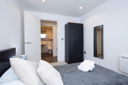 マンチェスターにあるModern MediaCity 2Bed Apartment, Amazing Views, Smart TVsのベッドルーム(白いベッド1台、鏡付)