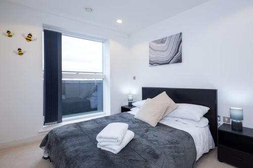 マンチェスターにあるModern MediaCity 2Bed Apartment, Amazing Views, Smart TVsのベッドルーム1室(ベッド1台、タオル2枚付)