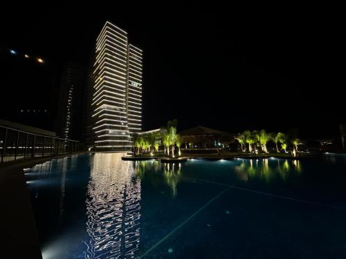 a tall building at night with a swimming pool at 2 Bedroom Amazing sea view Grand Sapphire in Iskele