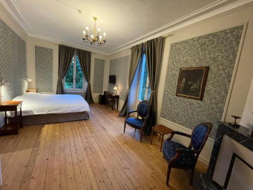 1 dormitorio con 1 cama y sillas en una habitación en Château De La Coutancière, en Brain-sur-Allonnes