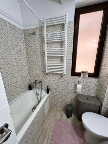 a bathroom with a tub and a toilet and a sink at Nathallie Cosy Apartment in Timişoara