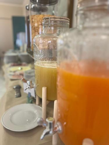a glass jar of orange juice next to a plate at Hotel San Francesco in San Giovanni Rotondo