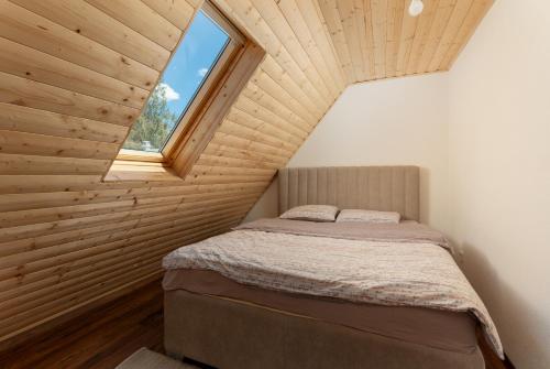 a bedroom with a bed in a room with a window at Lake house Sreten in Šavnik