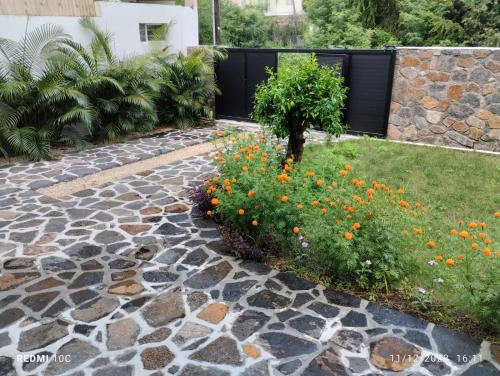 un jardín con una pasarela de piedra y flores en VILLA TROU AUX BICHES, en Trou aux Biches