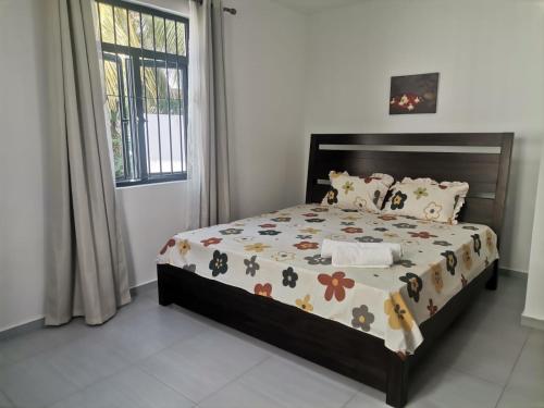 Un dormitorio con una cama con un edredón floral. en VILLA TROU AUX BICHES, en Trou aux Biches