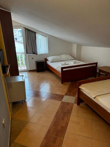 a bedroom with a bed and a wooden floor at Guesthouse Vila Tamburic in Becici