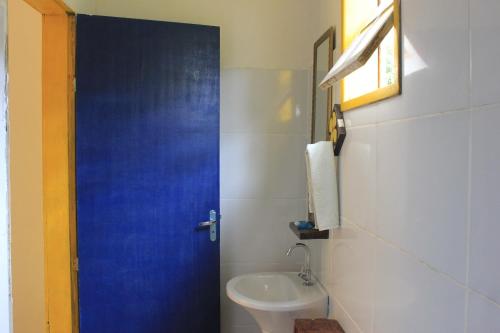 Chalé na floresta com frigobar في أورو بريتو: حمام بباب ازرق ومغسلة