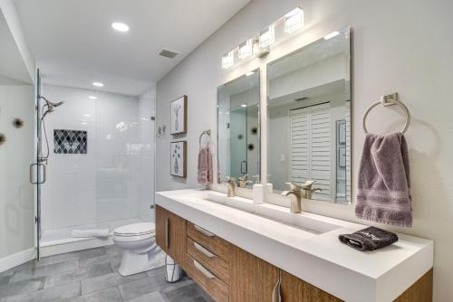 a bathroom with a sink and a toilet and a mirror at Modern Isla Del Sol Condo Walk to St Pete Beach! in St Petersburg