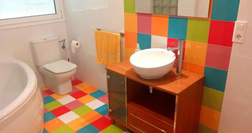 Baño colorido con lavabo y aseo en Habitaciones céntricas en Tàrrega, en Tàrrega