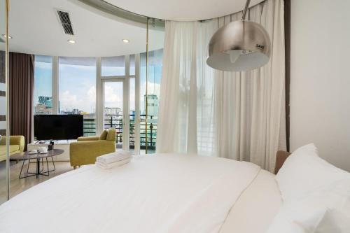 a bedroom with a white bed and a large window at The Rixx Ben Thanh Tower - The One Saigon in Ho Chi Minh City
