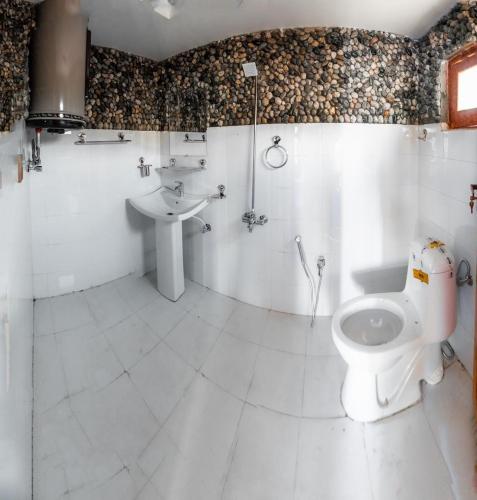 a bathroom with a toilet and a sink at Royal Brangsa Guest House in Skardu