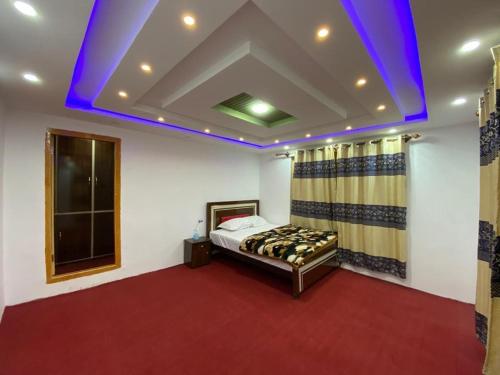 - une chambre avec un lit et un plafond violet dans l'établissement Royal Brangsa Guest House, à Skardu