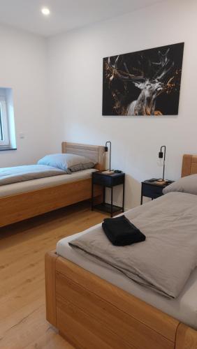 a bedroom with two beds and a painting on the wall at Ferienwohnung Zur Hofreite in Mörlenbach