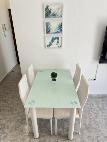 a white table with white chairs and a plant on it at Cabildo 3 in Sanlúcar de Barrameda