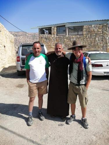 three men posing for a picture in a parking lot at nujum dana in Dana