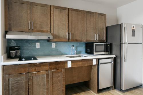 a kitchen with wooden cabinets and a white refrigerator at Homewood Suites By Hilton Dillon in Dillon