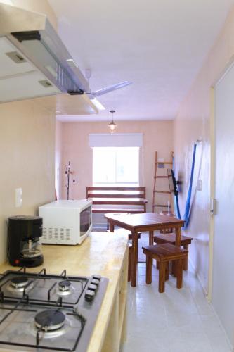 a kitchen with a stove and a table and chairs at Kin Tulum Apartamentos in Tulum