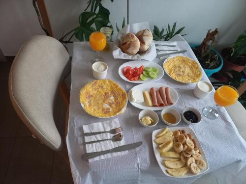 a table with breakfast foods and orange juice on it at Vila HK in Krujë
