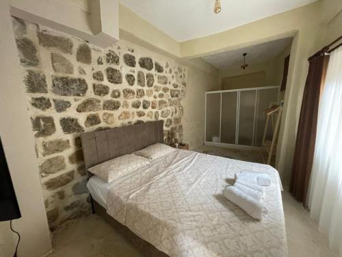a bedroom with a stone wall and a bed at İMS ÇARŞI OTEL in Mardin
