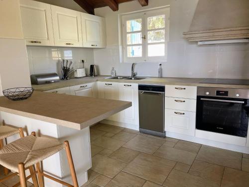 a kitchen with white cabinets and a counter top at Villa Pelagos in Tselendáta
