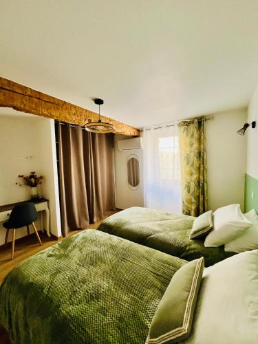 - une chambre avec 2 lits verts et une fenêtre dans l'établissement Les Gites d'Andréa - Chez Madame Yvon, à Surba