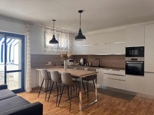 a kitchen with a table and chairs in a room at La Maison de Monique in Policoro