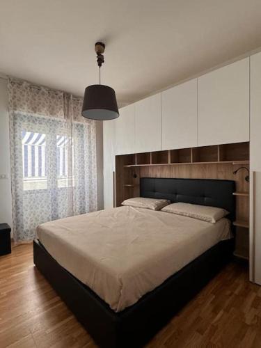 a bedroom with a large bed and a large window at La Maison de Monique in Policoro