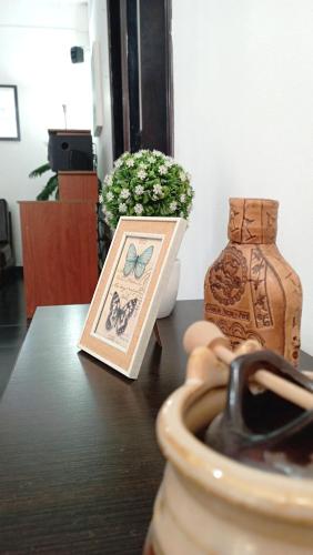 Una mesa con una imagen de una mariposa y un jarrón. en Apartamento Aeromar, Santa Marta, en Santa Marta