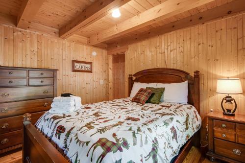 una camera con un letto in una baita di tronchi di Lake Lure Oasis in the Woods w/ Hot Tub & More! a Lake Lure