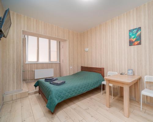 1 dormitorio con cama y mesa de madera en Затишна студія, 5 хвилин від Південного вокзалу en Járkov
