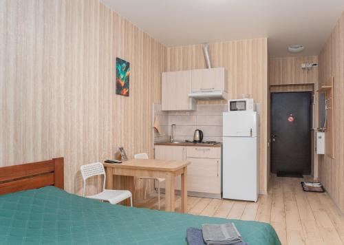eine kleine Küche mit einem Tisch und einem Kühlschrank in der Unterkunft Затишна студія, 5 хвилин від Південного вокзалу in Kharkov