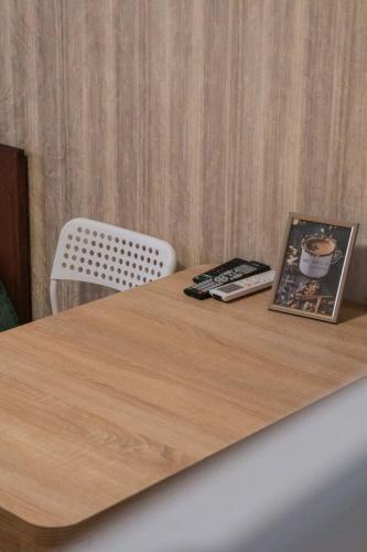 a wooden table with a book and a magazine on it at Затишна студія, 5 хвилин від Південного вокзалу in Kharkiv