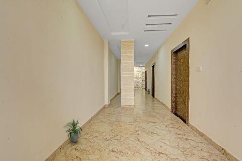 an empty hallway with a plant in the middle of a room at Hotel O The Heart Residency in Rāmgarh